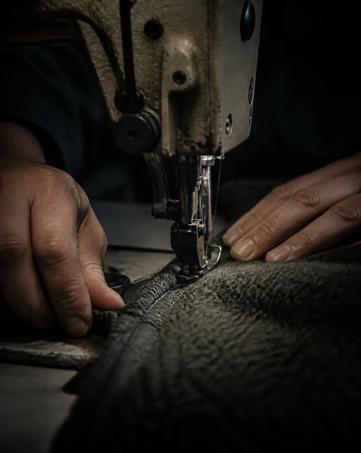 Close-up of an industrial sewing machine stitching heavyweight fleece fabric